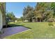 Lush backyard showcasing a patio, green lawn, and mature trees offering shade at 6724 Long Nook Ln, Indian Trail, NC 28079
