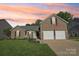 Charming brick home featuring a two-car garage, well-manicured lawn, and patriotic American flag at 6724 Long Nook Ln, Indian Trail, NC 28079
