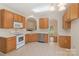 Well-lit kitchen boasts wood cabinets, white appliances, and an open layout with views to other rooms at 6724 Long Nook Ln, Indian Trail, NC 28079