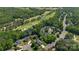 Aerial view showcases homes in a golf community, ponds, mature trees, and well-maintained streets at 7700 Ninth Fairway Ln, Mint Hill, NC 28227