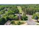 This aerial view showcases the home nestled in a golf course community, bordered by mature trees and landscaping at 7700 Ninth Fairway Ln, Mint Hill, NC 28227