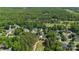 This aerial view captures homes nestled in a golf community amidst lush trees and greens at 7700 Ninth Fairway Ln, Mint Hill, NC 28227
