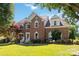 Beautiful two-story brick home featuring a well-maintained lawn and mature landscaping at 7700 Ninth Fairway Ln, Mint Hill, NC 28227
