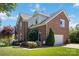 A brick two-story house features a side entry garage and a well manicured lawn at 7700 Ninth Fairway Ln, Mint Hill, NC 28227