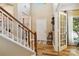 Welcoming foyer with hardwood floors, staircase, and plenty of natural light at 7700 Ninth Fairway Ln, Mint Hill, NC 28227