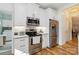 Modern kitchen with stainless steel appliances, white cabinets, and stylish backsplash at 7700 Ninth Fairway Ln, Mint Hill, NC 28227