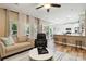 An open living room features hardwood floors, a ceiling fan, and seamless flow to kitchen at 7700 Ninth Fairway Ln, Mint Hill, NC 28227