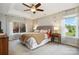 Spacious main bedroom featuring a tray ceiling, large windows, and stylish gray tufted headboard at 7700 Ninth Fairway Ln, Mint Hill, NC 28227