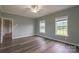 Bedroom featuring hardwood floors, ceiling fan, and bright windows offering views of the outside at 7740 Freeze Rd, Kannapolis, NC 28081