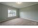This bedroom features neutral walls and carpet, a window, and white trim at 7740 Freeze Rd, Kannapolis, NC 28081