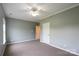 Bedroom featuring neutral carpet and paint with a ceiling fan and a doorway at 7740 Freeze Rd, Kannapolis, NC 28081