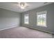 Bedroom featuring neutral carpet and paint with two windows at 7740 Freeze Rd, Kannapolis, NC 28081