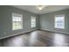 Bedroom featuring hardwood floors, ceiling fan, and bright windows offering views of the outside at 7740 Freeze Rd, Kannapolis, NC 28081