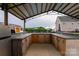 Well-equipped outdoor kitchen and bar with wood cabinetry, sink, and ample counter space at 7740 Freeze Rd, Kannapolis, NC 28081