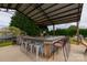 Covered outdoor bar area with seating, pool, and a serene backyard view at 7740 Freeze Rd, Kannapolis, NC 28081