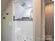 Modern shower features grey stone tiling, white subway tiles, a bench and a rainfall shower head at 7740 Freeze Rd, Kannapolis, NC 28081
