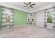 Bright bedroom with green accent wall, ceiling fan, carpeted floor and large windows with natural light at 8210 Festival Way, Charlotte, NC 28215