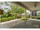 Covered patio offering views of a landscaped backyard and mature trees at 8210 Festival Way, Charlotte, NC 28215