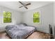 Bedroom features wood-look flooring, ceiling fan, and two windows for natural light at 93 34Th Street Nw Ct, Hickory, NC 28601