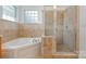 Bright bathroom features a soaking tub, separate glass shower and tiled surround at 9588 Marquette Nw St, Concord, NC 28027