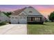 Charming two-story home featuring an attached two-car garage, manicured lawn, and stone-accented porch at 9588 Marquette Nw St, Concord, NC 28027