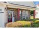 Inviting front porch featuring stone pillars, a red door, manicured bushes and large picture windows at 9588 Marquette Nw St, Concord, NC 28027