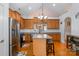 Bright kitchen boasts stainless steel appliances, island, breakfast bar, light wood cabinets and wood floors at 9588 Marquette Nw St, Concord, NC 28027