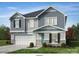 Charming two-story home with a light blue door, gray siding, stone accents, and a two-car garage at 1001 Cunningham Farm Dr, Indian Trail, NC 28079