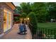 Backyard with Adirondack chairs on a stone patio overlooking a well-maintained lawn at 1001 Medinah Ct, Waxhaw, NC 28173