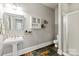 Bathroom featuring pedestal sink, tiled floor, decorative wall shelves, and glass-enclosed shower at 1001 Medinah Ct, Waxhaw, NC 28173