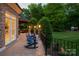 Outdoor patio with rocking chairs, brick pillars with outdoor lighting, and a view of the backyard at 1001 Medinah Ct, Waxhaw, NC 28173