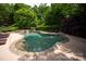 Backyard pool featuring stone steps, surrounded by lush greenery for a private retreat at 1001 Medinah Ct, Waxhaw, NC 28173