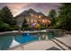 Backyard with an in-ground pool and stone waterfall feature, surrounded by lush landscaping at 1001 Medinah Ct, Waxhaw, NC 28173