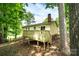 View of the home from the trees highlighting the wooden deck and a partial view of the back yard at 1018 Autumn Ln, Hickory, NC 28602