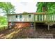 Back of house featuring a brick foundation, back windows, and wooden deck at 1018 Autumn Ln, Hickory, NC 28602