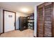 Finished basement area with carpet flooring, storage shelves, safe, and wooden closet doors at 1018 Autumn Ln, Hickory, NC 28602