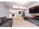 Spacious basement featuring a painted brick fireplace, gray sofa and large television at 1018 Autumn Ln, Hickory, NC 28602