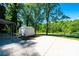 Long concrete driveway with a carport and storage shed in a wooded area at 1018 Autumn Ln, Hickory, NC 28602