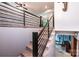 A modern staircase with black metal railings leading to a lower level with exercise equipment at 1018 Autumn Ln, Hickory, NC 28602