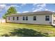 View of the back of the home showcasing its light yellow siding and well-manicured lawn at 106 Rainbow Sw St, Concord, NC 28025
