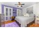 Bedroom with hardwood floors, multiple windows and a plush bed with a gray comforter at 106 Rainbow Sw St, Concord, NC 28025