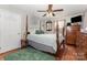 Bedroom with ceiling fan, wooden four-poster bed, hard wood floors, and green accent rug at 106 Rainbow Sw St, Concord, NC 28025