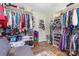 Walk-in closet with hardwood floors, shelves, storage, racks, and a gray loveseat at 106 Rainbow Sw St, Concord, NC 28025