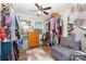 Walk-in closet with hardwood floors, storage, shelves, racks, and a small gray loveseat at 106 Rainbow Sw St, Concord, NC 28025