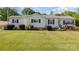 Inviting single-story home with a well-maintained lawn and a relaxing front porch swing at 106 Rainbow Sw St, Concord, NC 28025