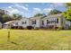 Beautifully maintained home with a lush lawn, mature trees, and a welcoming porch swing at 106 Rainbow Sw St, Concord, NC 28025