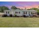 Charming single-story home with a well-manicured lawn and a cozy front porch swing at 106 Rainbow Sw St, Concord, NC 28025