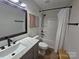 Bright bathroom featuring a modern vanity, sink, and a bathtub with a showerhead and white curtain at 11216 Carmel Chace Dr, Charlotte, NC 28226
