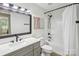 Bathroom featuring a grey vanity, modern fixtures, wood floors, and a shower with a tub for a relaxing experience at 11216 Carmel Chace Dr, Charlotte, NC 28226