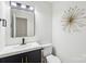 Modern half bathroom with a black vanity, a white countertop, and a sleek faucet, blending style and functionality at 11216 Carmel Chace Dr, Charlotte, NC 28226